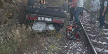 DURSUNBEY'DE OTOMOBİL ŞARAMPOLDEN TREN YOLUNA UÇTU